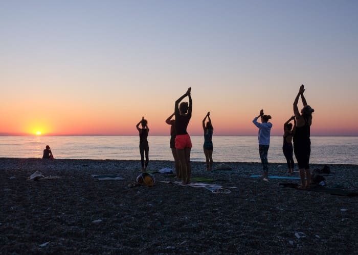yoga on beach with sunset