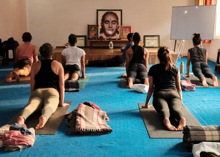 a group of people sitting on the floor in a room, likely engaged in a yoga session